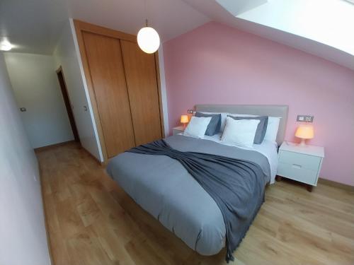 a bedroom with a large bed with purple walls at ÁTICO MIRADOR Costa Da Morte in Ponteceso
