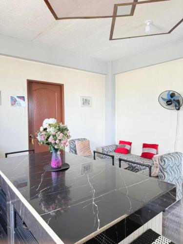 a room with a table with a vase of flowers on it at Mountain Cove Villa in Pagudpud