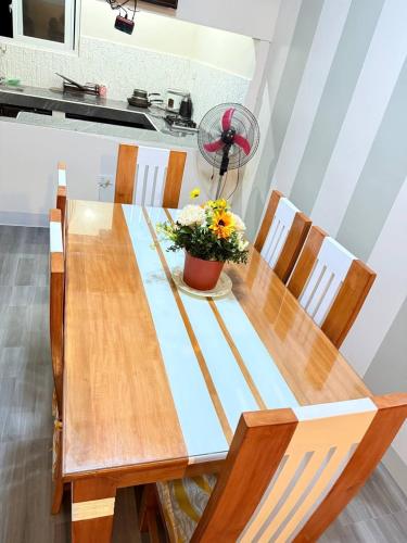 a wooden table with a vase of flowers on it at Mountain Cove Villa in Pagudpud