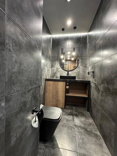 a bathroom with a black toilet and a mirror at A&M Apartaments GREY - New Building in Yerevan