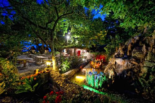 a garden lit up at night with lights at Nepheli Hotel in Kastrosikia