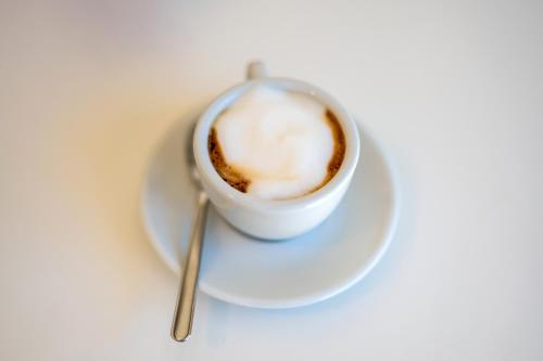 a cup of coffee on a plate with a spoon at Il Casale nel Parco in Ostuni