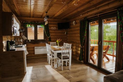 科尔别卢夫Chaty pod Pilskiem - sauna i jacuzzi w cenie的配有桌椅的厨房和餐厅