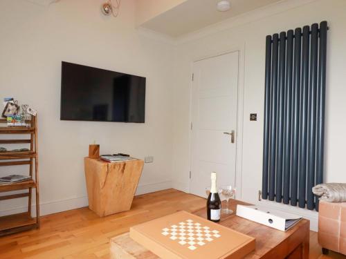 a living room with a coffee table and a tv at Sea View in St Austell