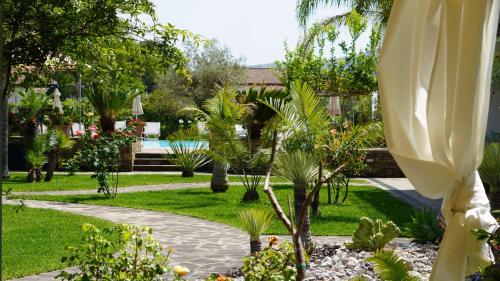a garden with palm trees and a swimming pool at Cuore del Cilento Relais&Retreat in Castellabate