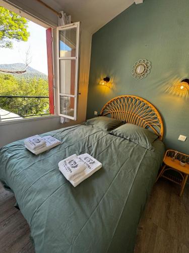 - une chambre avec un lit vert et 2 serviettes dans l'établissement Villa Leona 3 Chambres et parc aquatique - Les Restanques, à Grimaud
