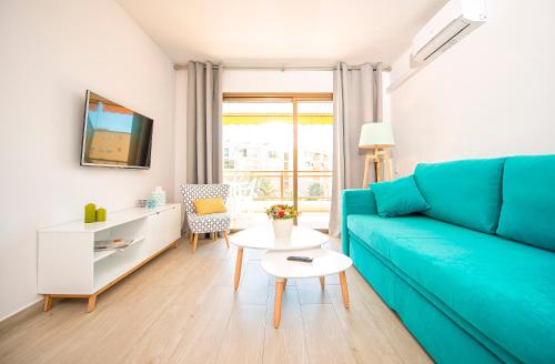 a living room with a blue couch and a table at Ona Aquamarina in La Pineda