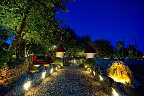 a garden at night with lights on the ground at Nepheli Hotel in Kastrosikia