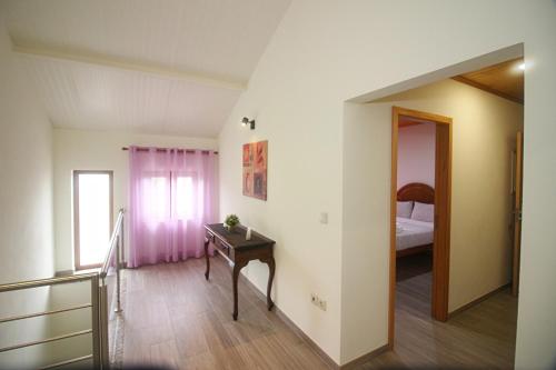 a room with a table and a bed and a window at Casa da Carvalha Mona in Rio Caldo