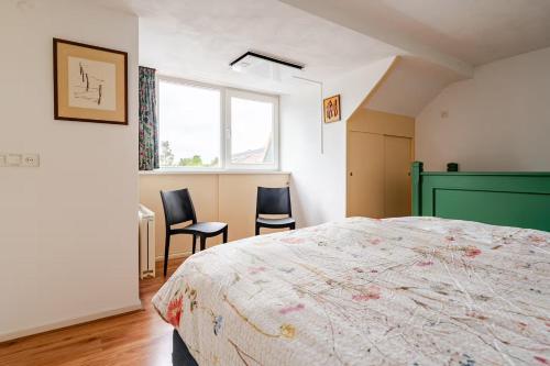 una camera da letto con un letto e due sedie di Huisje Marie Loosdrecht, bootverhuur mogelijk a Loosdrecht