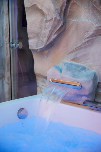 a bath tub with water coming out of a faucet at Podere Raffanna Ecologic House in Massa e Cozzile