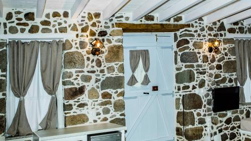 a kitchen with a stone wall with a window at Rodakas Rooms-Ariadni in Kondiás