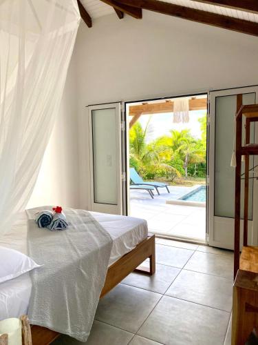 a bedroom with a bed and a sliding glass door at Kôsy in Grand-Bourg
