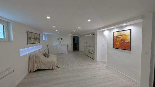 - un salon avec des murs blancs et du parquet dans l'établissement Les Loges de la Gallée, à Millery