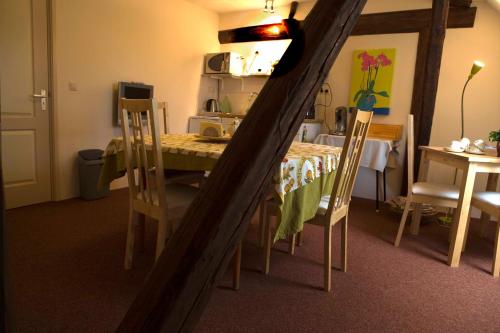 a table and chairs in a room with a kitchen at Bed & Breakfast Onder Dak in Scharmer
