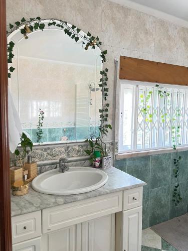 a bathroom with a sink and a large mirror at Pink House - Lisbon in Lisbon