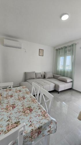 a white living room with a table and a couch at ValMar in Bar, Susanj