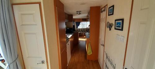 un couloir d'une petite cuisine avec un couloir dans l'établissement MOBILHOME 50m plage DINARD, à Dinard