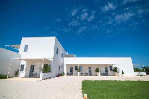 a white house with a lawn in front of it at Il Casale nel Parco in Ostuni