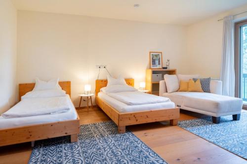 a bedroom with two twin beds and a couch at Landvilla Modersnhof mit Pool in Weiz