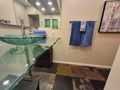 een badkamer met een glazen wastafel en blauwe handdoeken bij Central - 2 Pools BBQ Jacuzzi Bath in Phoenix