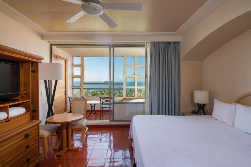 a hotel room with a bed and a view of the ocean at Club Regina Puerto Vallarta in Puerto Vallarta