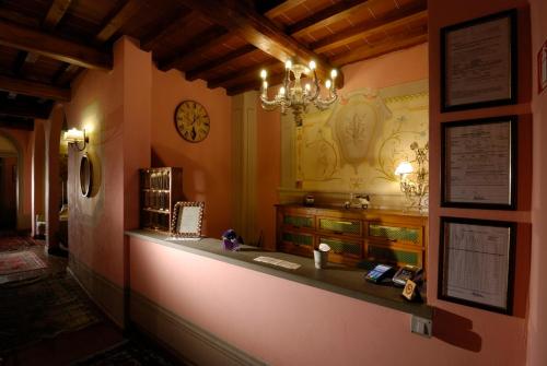 a long counter in a room with a clock on the wall at Locanda San Barnaba in Scarperia