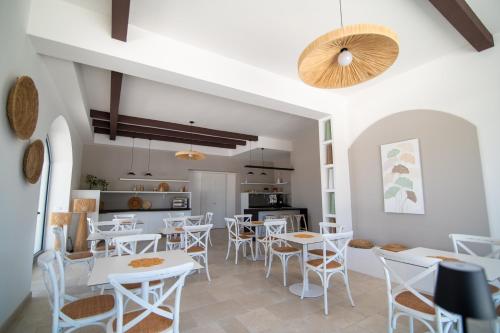 a dining room with white tables and chairs at Il Casale nel Parco in Ostuni