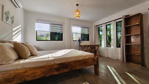 a bedroom with a large bed and some windows at 4 Amigos El Zonte in El Zonte