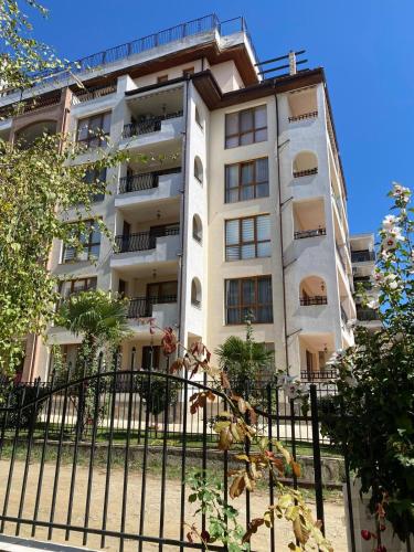 a tall building with a fence in front of it at Marina Park OLIWIA in Sveti Vlas