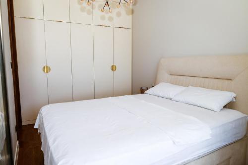a bedroom with a white bed and a chandelier at VistaPool Residence Kotor in Dobrota