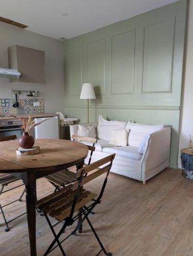 un salon avec un canapé blanc et une table dans l'établissement Maison au coeur du vignoble, à Loupiac-de-Cadillac