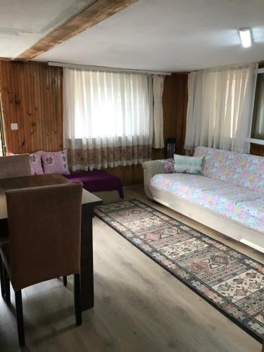 a living room with two beds and a table and a rug at Guesthouse Dolunay in Ayder Yaylasi