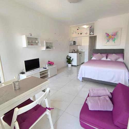 een slaapkamer met een bed en een bureau met een computer bij Cute studio-great location in Zadar