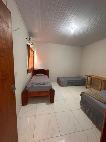 a room with two beds in a room with a ceiling at Casa 2min do Centro c Piscina in Bonito