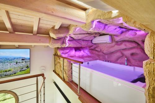 a room with a rock wall in a tiny house at Podere Raffanna Ecologic House in Massa e Cozzile