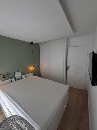 une chambre avec un grand lit blanc et une télévision dans l'établissement Super T2 Rénové Aperçu Mer Toutes Commodités, à Antibes