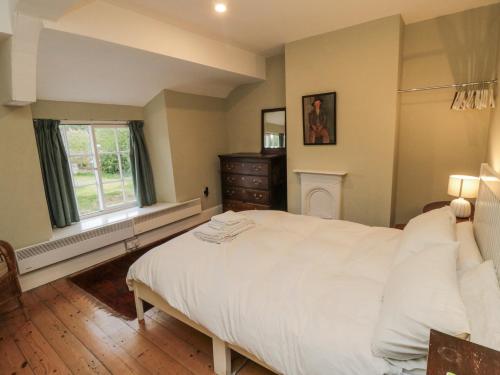 a bedroom with a large white bed and a window at Brookleigh in Hutton le Hole