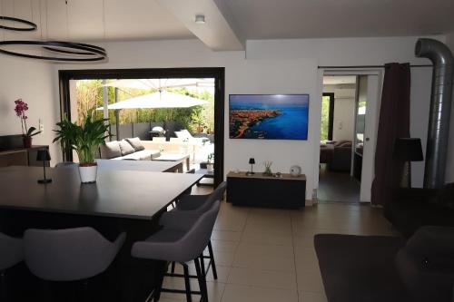 une salle à manger et un salon avec une table et des chaises dans l'établissement Spacious house for 8 with swimming pool, à Antibes