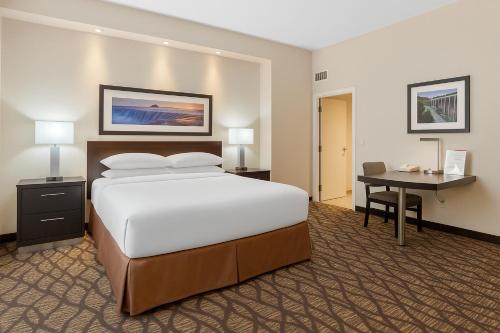 a hotel room with a large bed and a desk at Embassy Suites by Hilton Niagara Falls/ Fallsview in Niagara Falls