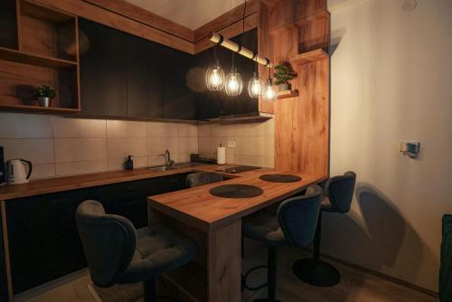 a kitchen with a wooden table and some chairs at Zeus Apartman in Jagodina