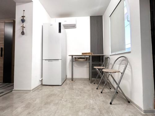 a kitchen with a refrigerator and a table and chairs at Studio Navae in Năvodari