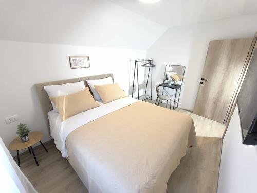 a white bedroom with a large bed and a table at Forza Blidinje in Blidinje