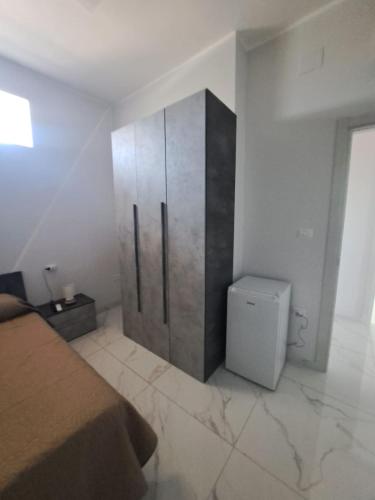 a bedroom with a refrigerator and a toilet at Le follie in Maddaloni