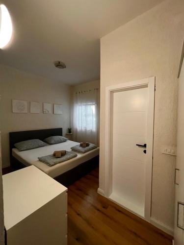 a bedroom with two beds and a white door at Apartman Lucia in Mimice