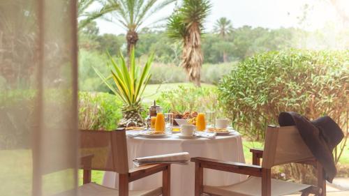 a table with a white table cloth on it with chairs at Tikida Golf Palace in Agadir