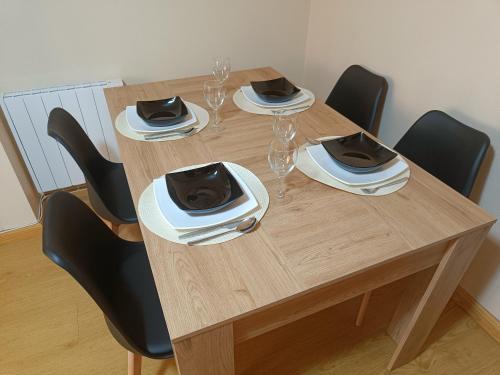 a wooden table with chairs and wine glasses on it at Piso PLAYA CANGAS CENTRO in Cangas de Morrazo