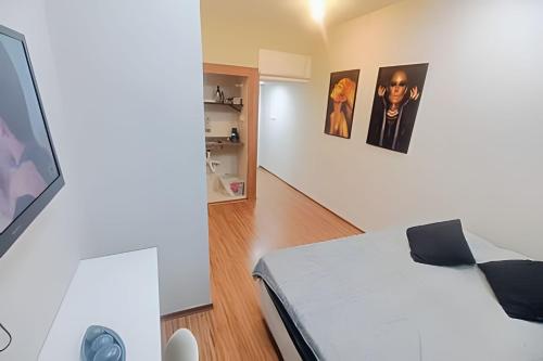 a bedroom with a bed and a tv on a wall at Studio 1103 - Centro Niterói in Niterói