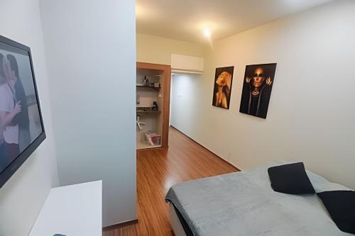 een kamer met een bed en foto's aan de muur bij Studio 1103 - Centro Niterói in Niterói