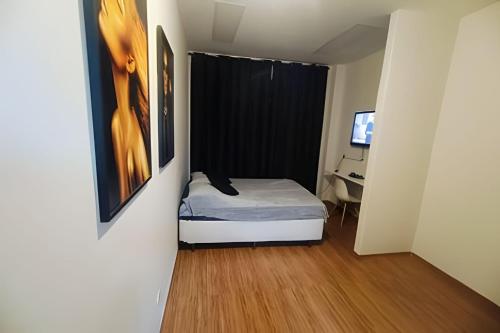 a small bedroom with a bed and a desk at Studio 1103 - Centro Niterói in Niterói
